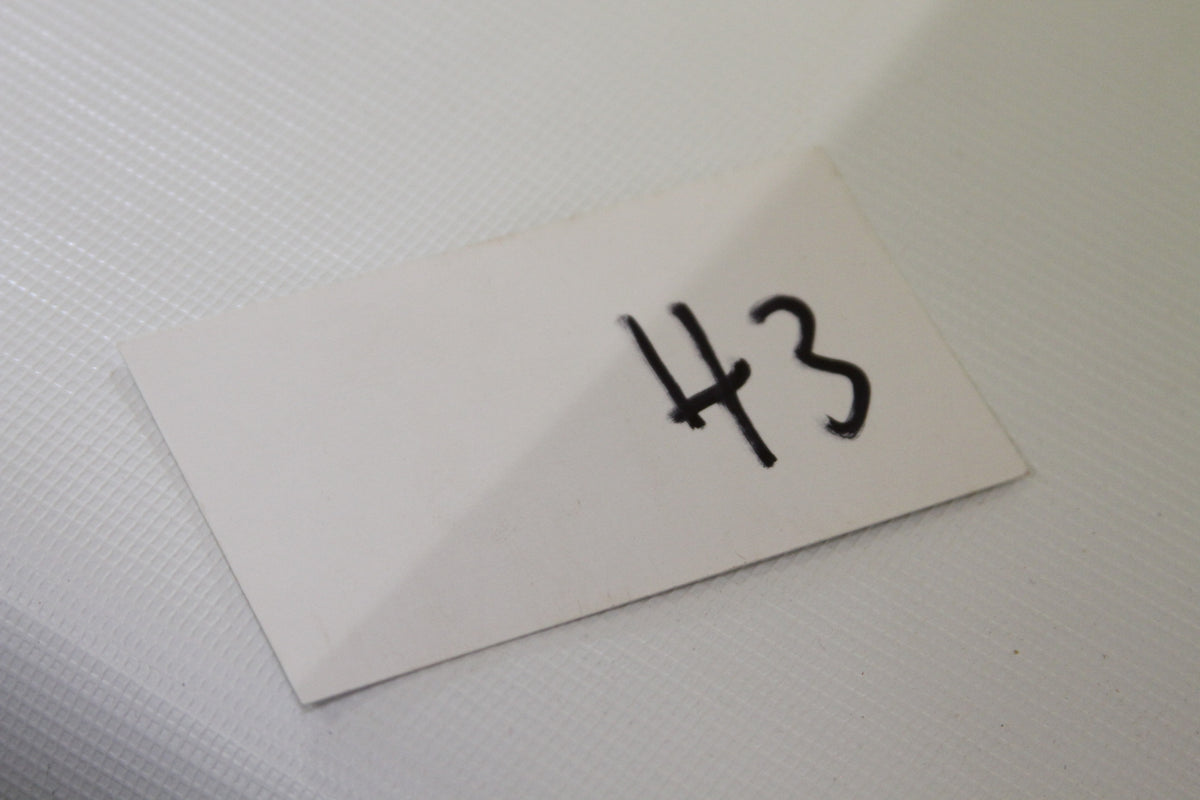 White card labeled 43 on white textured surface