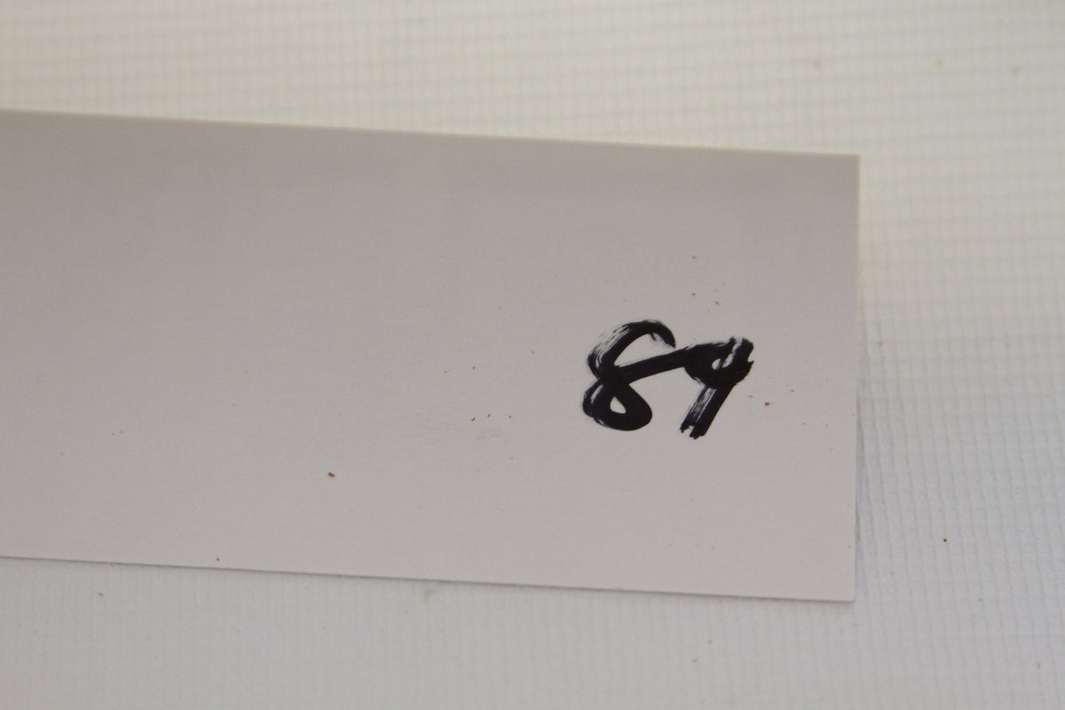 Handwritten label with number 84 on a white card