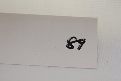 Handwritten label with number 84 on a white card
