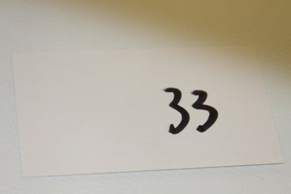 White card with handwritten number 33