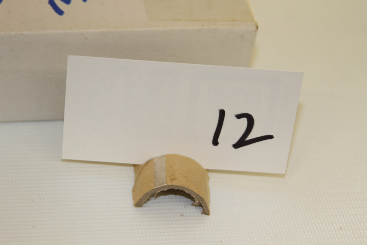 Close-up of number 12 tag and cardboard fragment by Topps Micro box