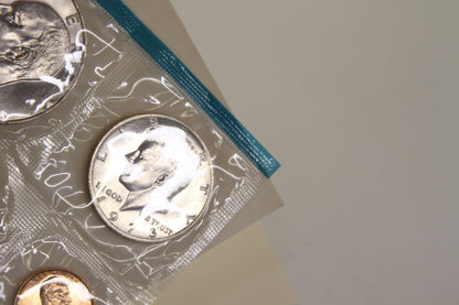 Close-up of 1973 Kennedy half dollar in blue-edged mint packaging