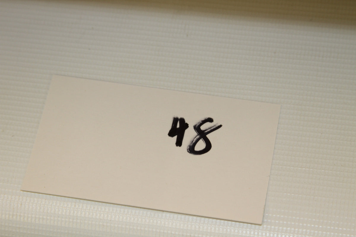 White card labeled 48 for lot or set identification