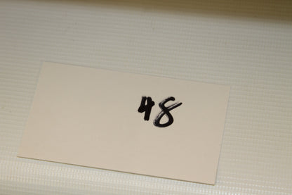 White card labeled 48 for lot or set identification