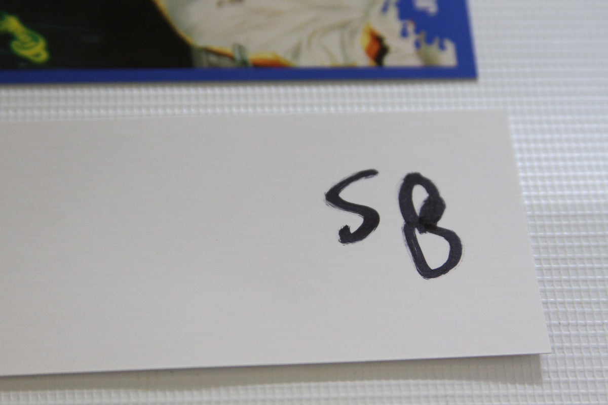 White sign with handwritten 'SB' next to cards