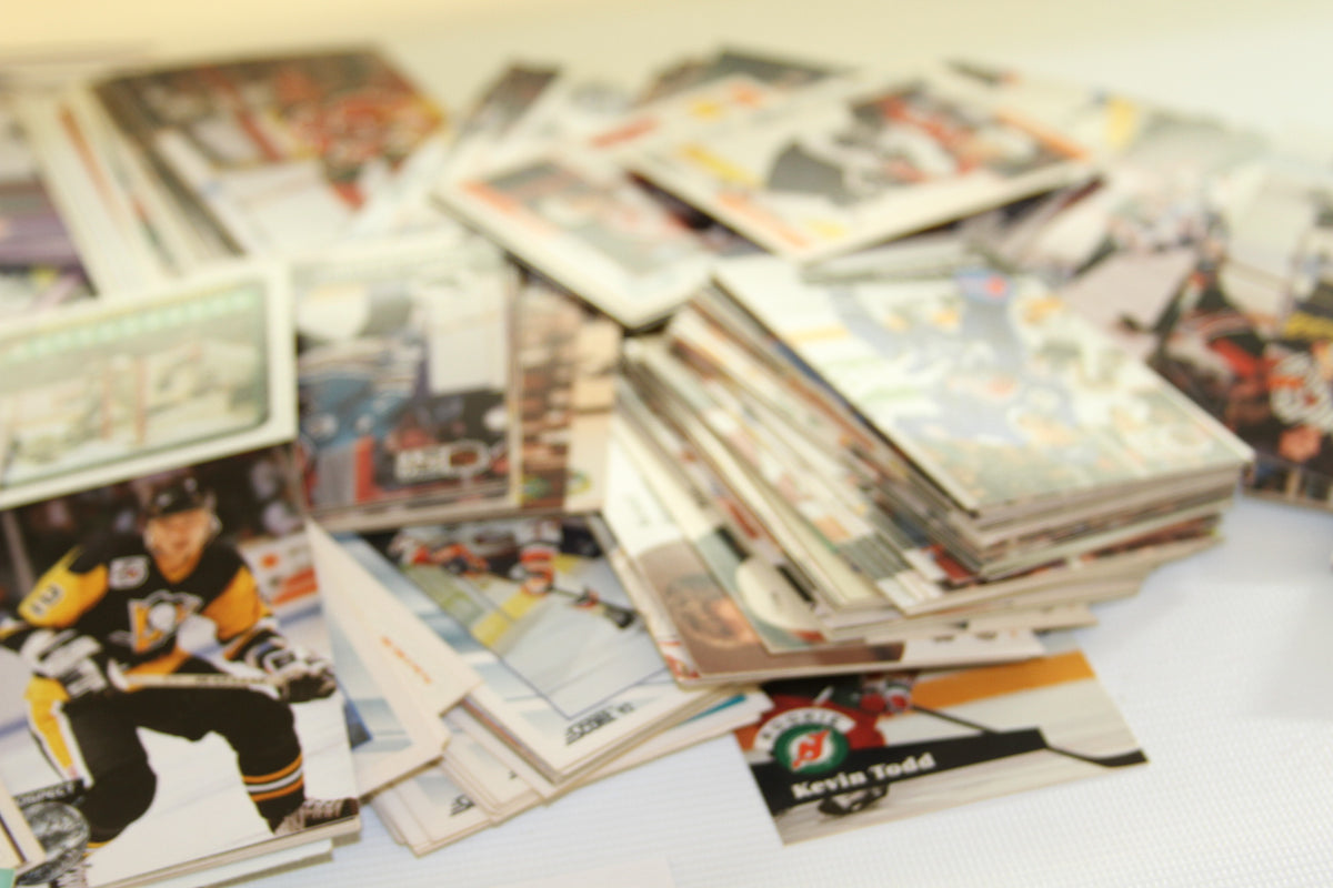 Blurred image of stacked hockey trading cards with a visible Pittsburgh Penguins player in front.