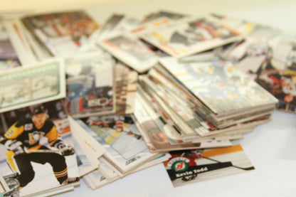 Blurred image of stacked hockey trading cards with a visible Pittsburgh Penguins player in front.