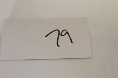Handwritten number 79 on card near the coin set