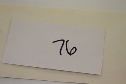Handwritten number 76 on white card from product lot