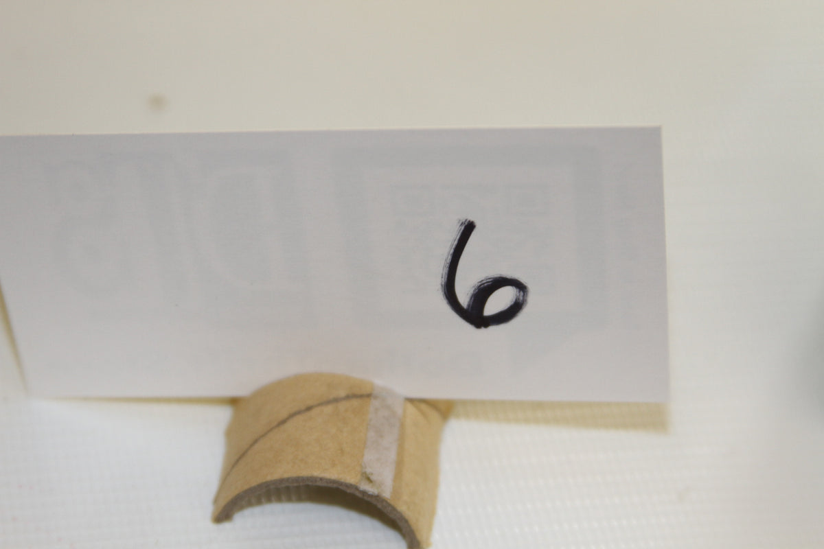 Cardboard holder with number 6 written on card, used for set identification