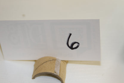 Cardboard holder with number 6 written on card, used for set identification